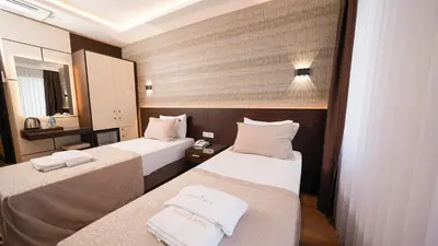 a hotel room with two beds and a mirror at Bellezza Hotel in Istanbul