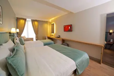 a hotel room with two beds and a desk at Days Inn by Wyndham Istanbul Arnavutkoy in Istanbul
