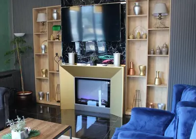 a living room with a tv and blue chairs at Aram Otel Business & Luxury in Istanbul