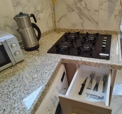 a kitchen counter with a stove and a microwave at Cozy Home Next to Green Mosque in Yıldırım