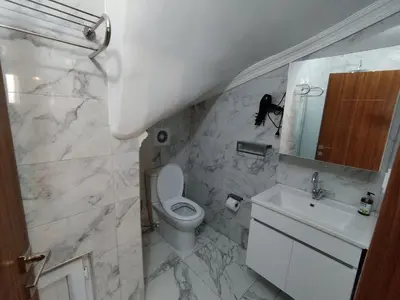 a bathroom with a toilet and a sink and a mirror at Cozy Home Next to Green Mosque in Yıldırım