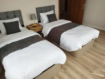 a bedroom with two beds and a night stand with at Cozy Home Next to Green Mosque in Yıldırım