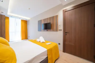 a bedroom with a bed and a tv on the wall at Garden Room Suit Hotel in Istanbul