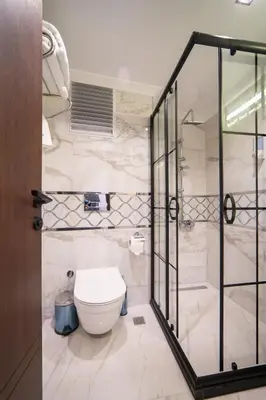 a bathroom with a toilet and a glass shower at Garden Room Suit Hotel in Istanbul