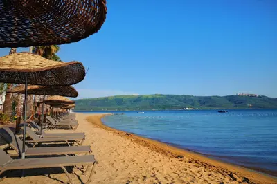 a group of chairs and umbrellas on a beach at Parmos Otel in Erdek