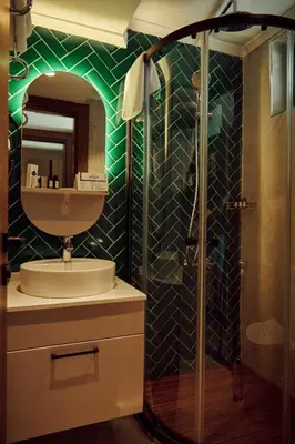 a bathroom with a sink and a shower with a mirror at Parmos Otel in Erdek