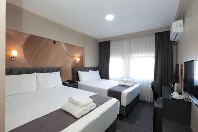 a hotel room with two beds and a flat screen tv at BURSA LOYAL CiTY HOTEL in Bursa