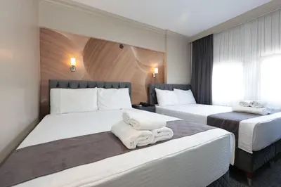 a hotel room with two beds with towels on them at BURSA LOYAL CiTY HOTEL in Bursa