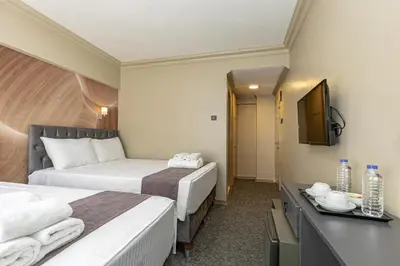 a hotel room with two beds and a television at BURSA LOYAL CiTY HOTEL in Bursa