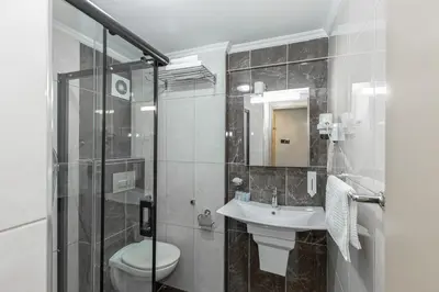 a bathroom with a toilet and a sink and a shower at BURSA LOYAL CiTY HOTEL in Bursa