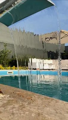 a water fountain in front of a swimming pool at Begonvil Konaklama in Sapanca