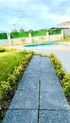 a stone path leading to a swimming pool at Begonvil Konaklama in Sapanca