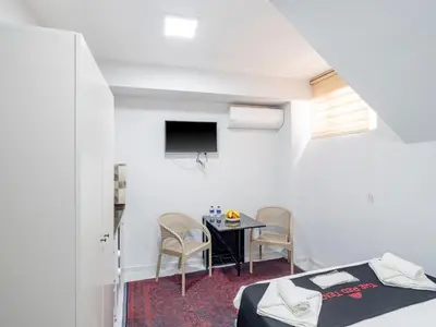 a room with a table and chairs and a tv at The Red Tent Suite 23 in Istanbul