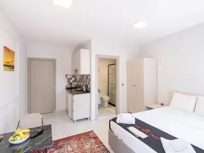 a white bedroom with a bed and a table at The Red Tent Suite 23 in Istanbul