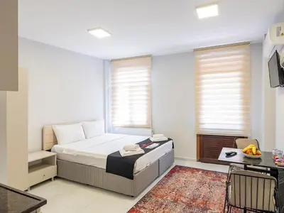 a bedroom with a bed and a table and windows at The Red Tent Suite 23 in Istanbul