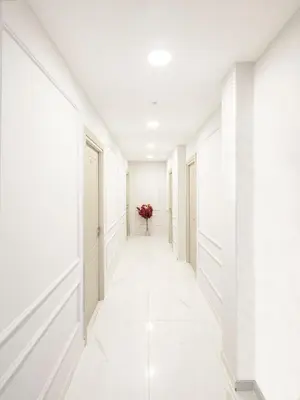 a hallway with white walls and white floors and a vase of flowers at The Red Tent Suite 23 in Istanbul