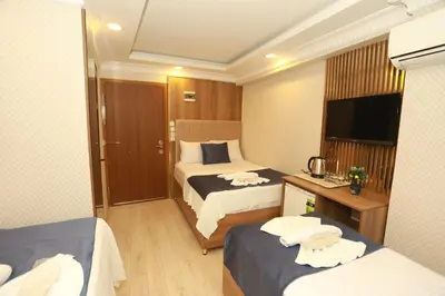 a hotel room with two beds and a flat screen tv at IMMORTELLE HOTEL lord sophiha in Istanbul