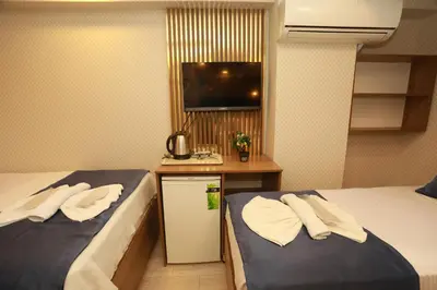 a hotel room with two beds and a television at IMMORTELLE HOTEL lord sophiha in Istanbul