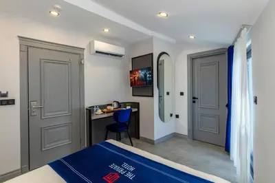 a bedroom with a bed and a desk and a mirror at The Private Airport Hotel in Istanbul