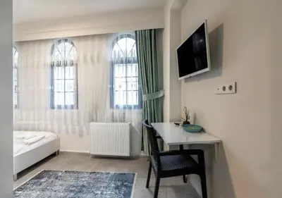 a room with a bed and a desk and a television at The Red Tent Social Hostel in Istanbul