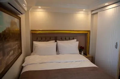 a bed with white sheets and pillows in a room at Blue Zerzevan Konak Hotel in Istanbul