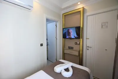 a bedroom with a bed with a television in it at Blue Zerzevan Konak Hotel in Istanbul