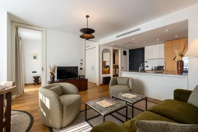 a living room with a couch and chairs and a kitchen at Ando Living Taksim House in Istanbul