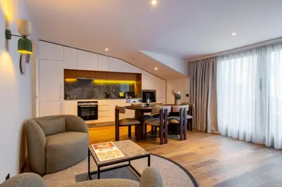 a living room with a table and chairs and a kitchen at Ando Living Taksim House in Istanbul