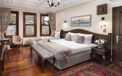 a bedroom with a large bed with a bench in it at Bender Hotel in Istanbul