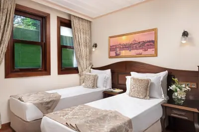 a hotel room with two beds and a window at Bender Hotel in Istanbul