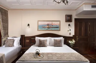 a hotel room with two beds and a table at Bender Hotel in Istanbul