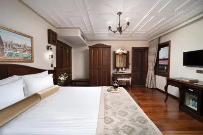a bedroom with a large white bed and a television at Bender Hotel in Istanbul