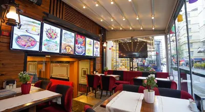 a restaurant with tables and chairs and a window at Fidan City Hotel in Istanbul