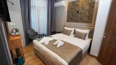a bedroom with a large bed with two towels on it at Fidan City Hotel in Istanbul