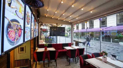 a restaurant with tables and chairs and a large window at Fidan City Hotel in Istanbul