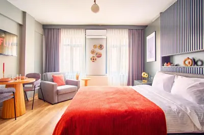 a bedroom with a bed and a chair and a table at TAKS-INN Hotel in Istanbul