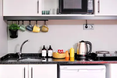 a kitchen counter with a sink and a microwave at TAKS-INN Hotel in Istanbul