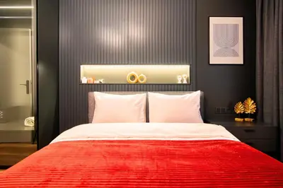 a bedroom with a large bed with a red blanket at TAKS-INN Hotel in Istanbul