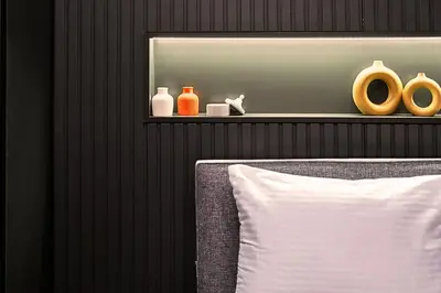 a wall with a shelf with vases and a pillow at TAKS-INN Hotel in Istanbul