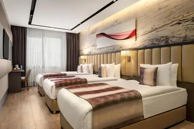 a hotel room with three beds in it at Ramada by Wyndham Istanbul Umraniye in Istanbul