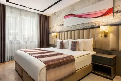 a hotel room with a bed and a painting on the wall at Ramada by Wyndham Istanbul Umraniye in Istanbul