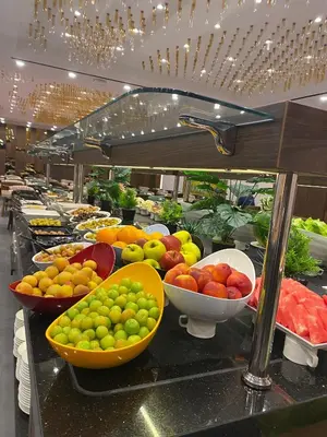 a buffet line with bowls of fruits and vegetables at Ramada by Wyndham Istanbul Umraniye in Istanbul