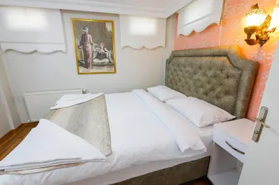 a bedroom with a large white bed and a picture on the wall at Fidelya Boutique Hotel in Sultanahmet