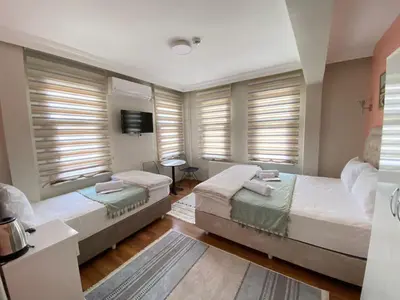 a bedroom with two beds and windows with blinds at Fidelya Boutique Hotel in Sultanahmet