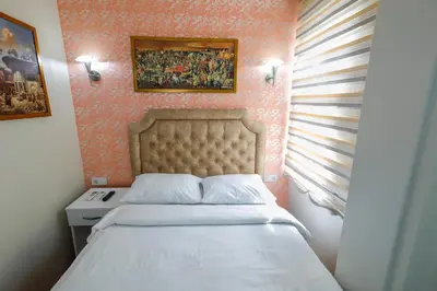 a small bedroom with a bed with a white bedspread at Fidelya Boutique Hotel in Sultanahmet