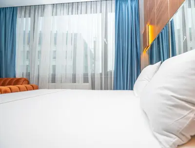 a bedroom with a white bed and a large window at Center Suite in Istanbul