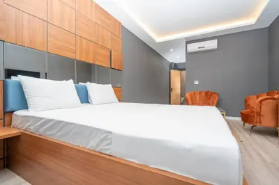 a bedroom with a large white bed and a chair at Center Suite in Istanbul