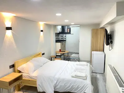 a bedroom with a large bed and a kitchen at La Perato in Istanbul