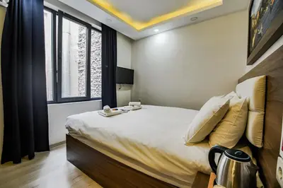 a bedroom with a large bed and a window at MITANI SUITES in Istanbul