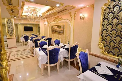 a dining room with white tables and blue chairs at Golden Marmara Hotel in Istanbul